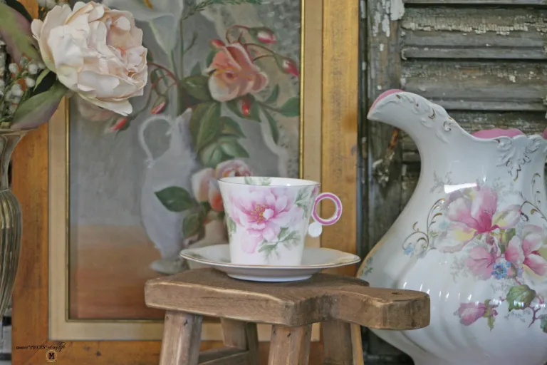 Gorgeous teacup vignette with vintage pitcher, painting, and flower