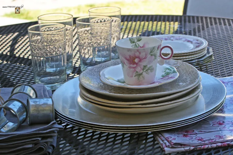 teacup with glasses, napkin rings, and stack of plates
