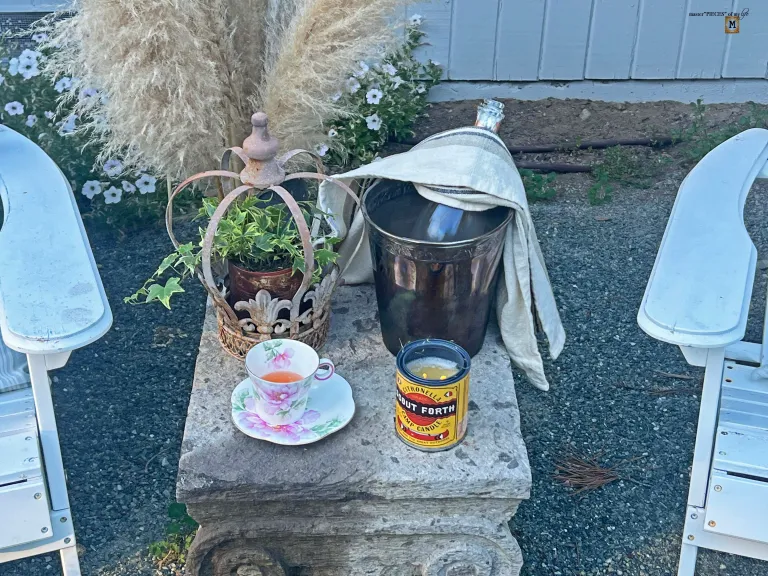 teacup with pink champagne on table with wine bucket and candle