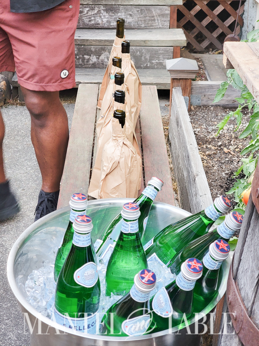 Last minute party - wine bottles in paper bags lined up on a bench