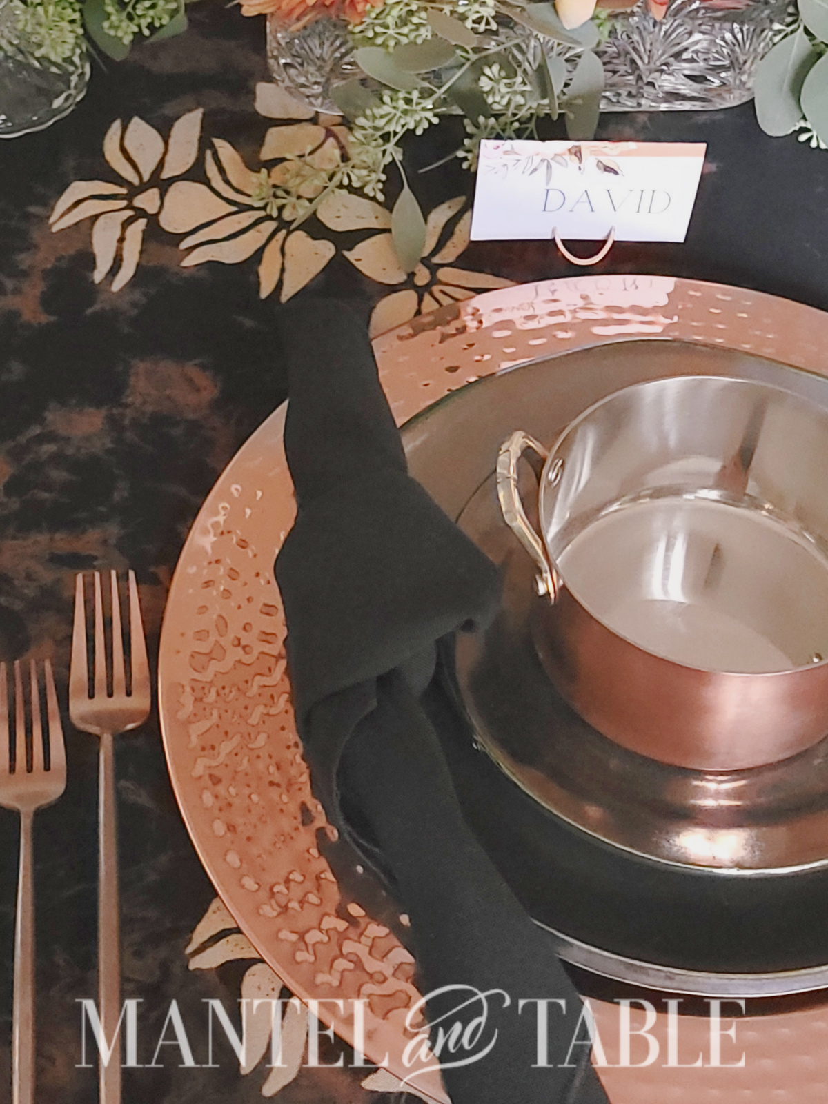 Copper and black place setting side view with coper forks