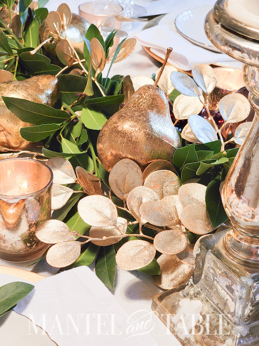 Gold faux pear, and eucalyptus leaf garland, gold candle holders in bay leaf garland centerpiece