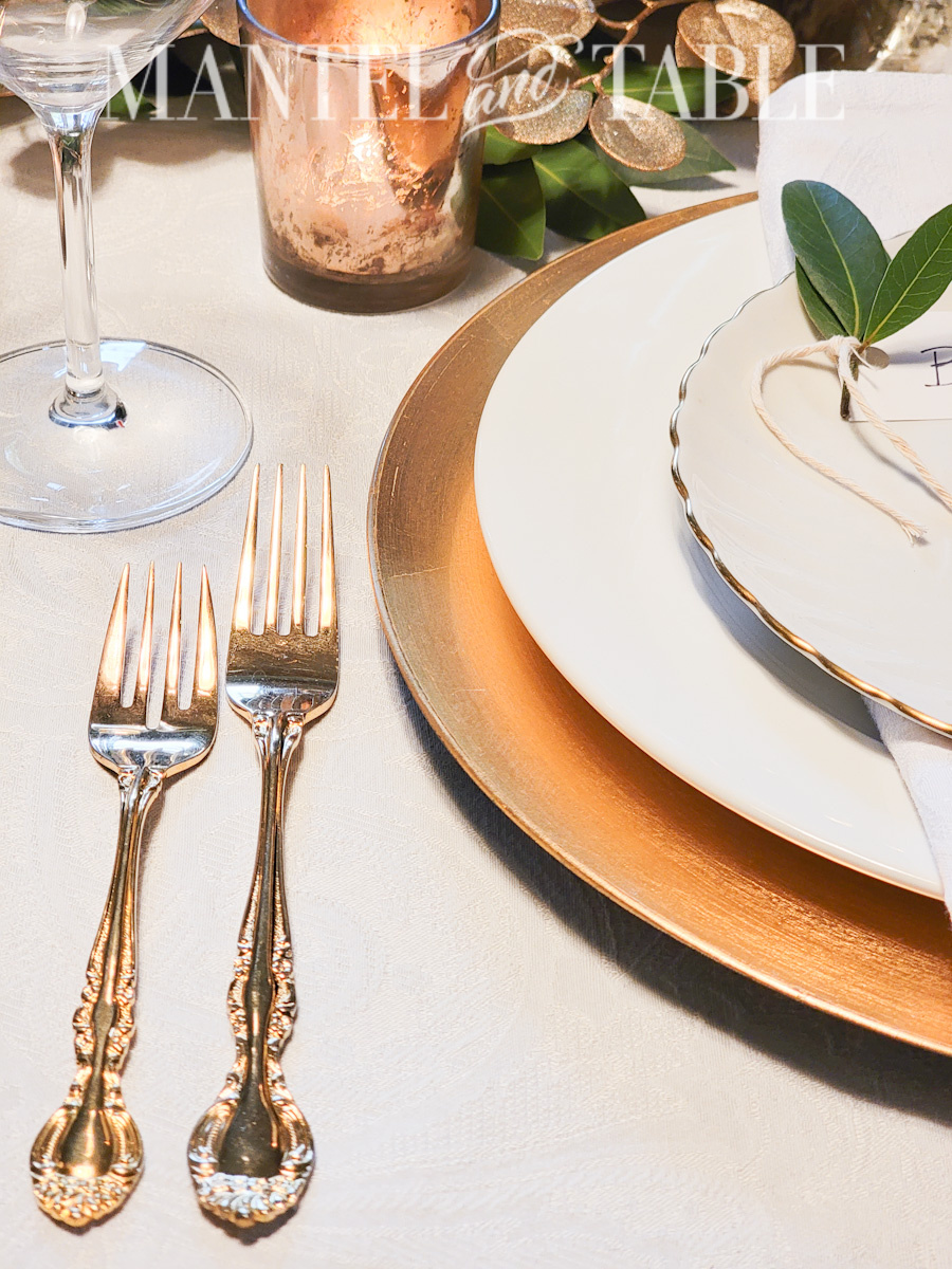 Gold and white plate stack on table with gold flatware