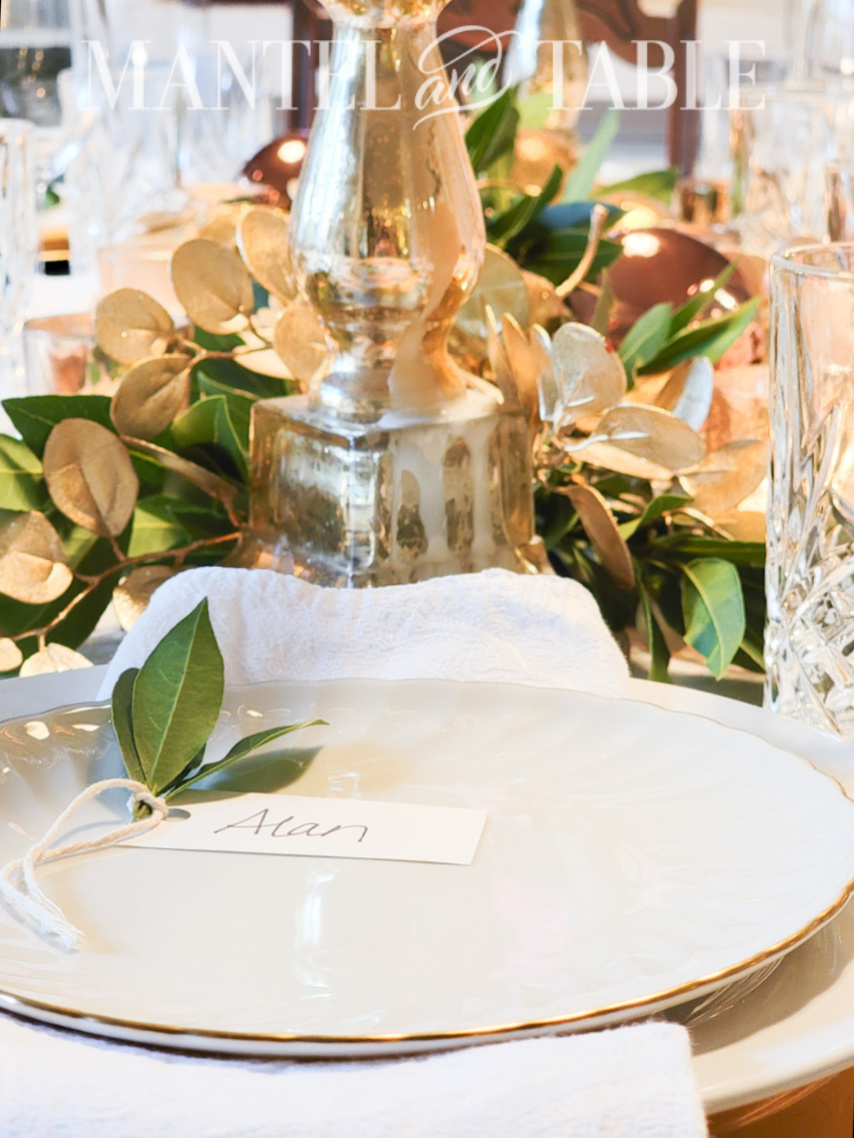Closeup of place card with bay leaf and string, on white plate
