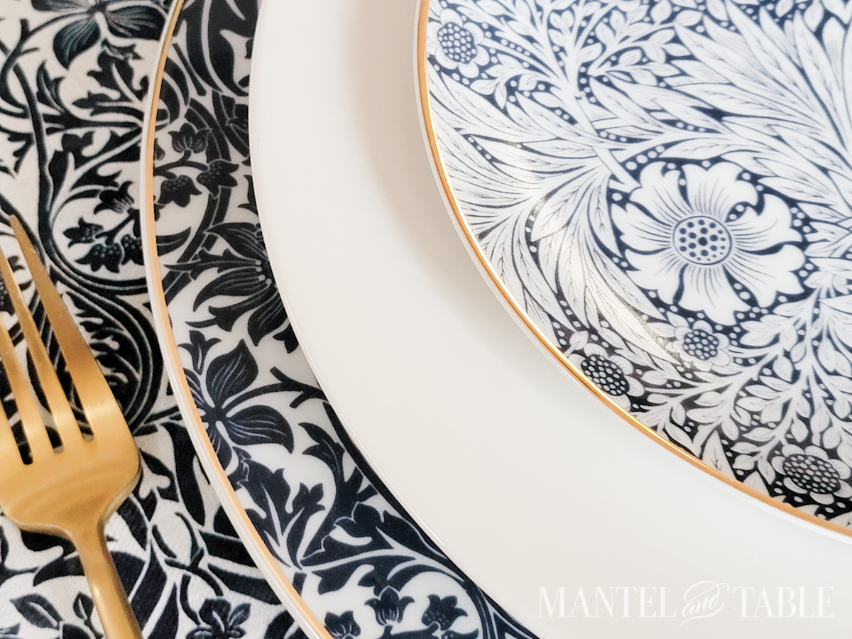 Closeup of three plates stacked on a blue tablescape