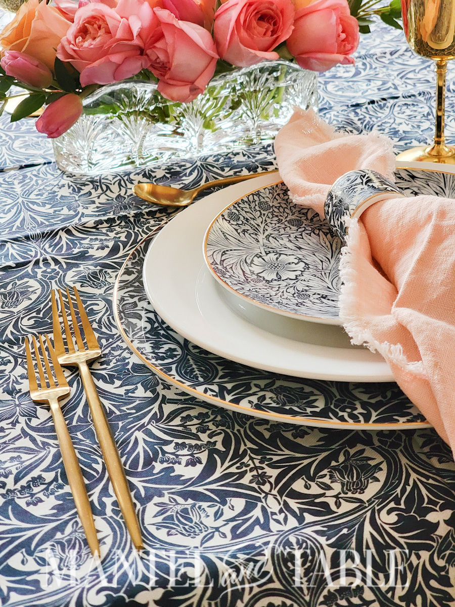 Formal place setting with centerpiece of pink roses in crystal dishes