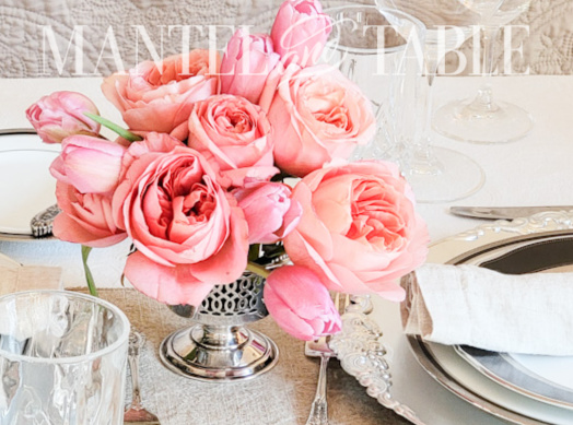 Pink flower arrangement in small vintage silver compote in formal table setting
