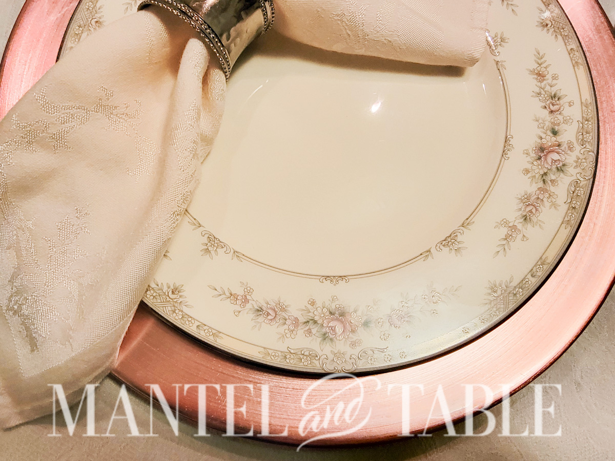 Closeup of dinner plate with a pink floral design on a cream background