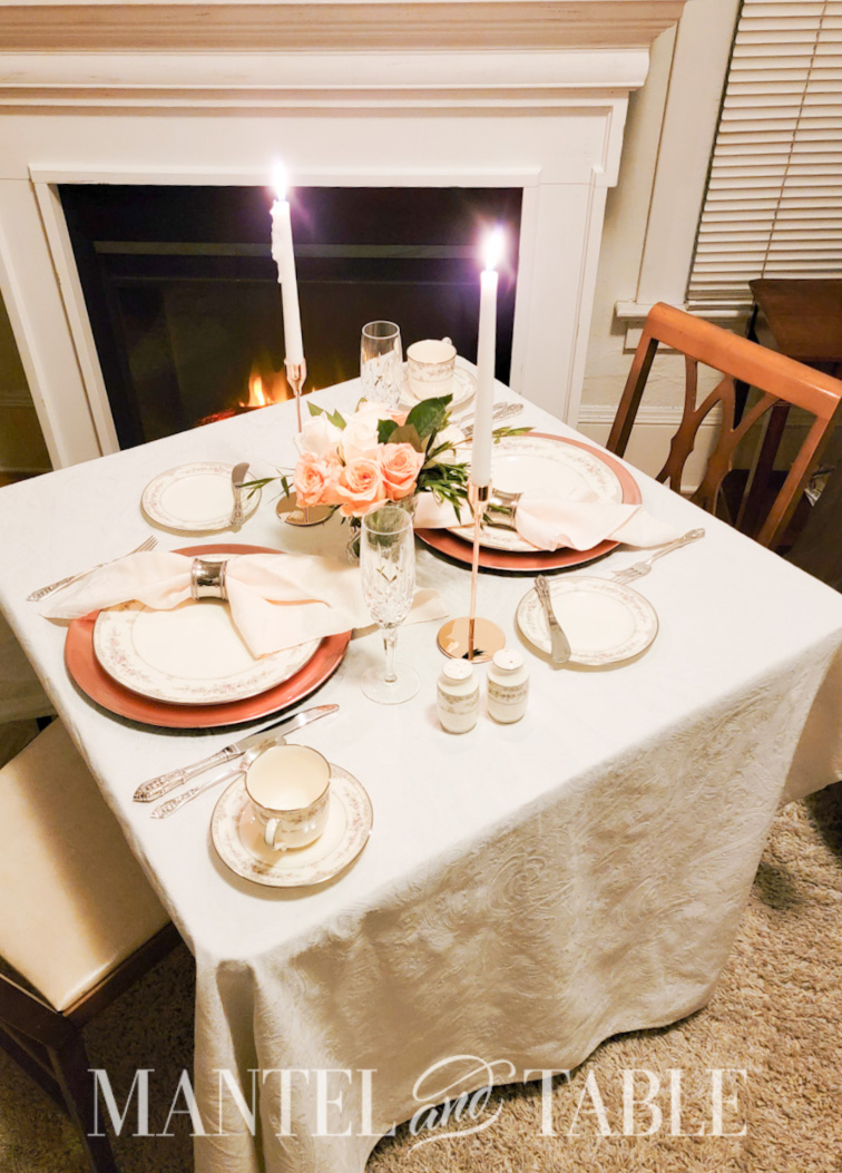 Peach colored Table for two in front of a fireplace