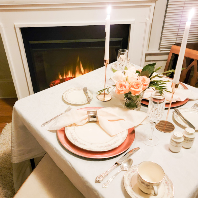 Table for two in front of a glowing fireplace