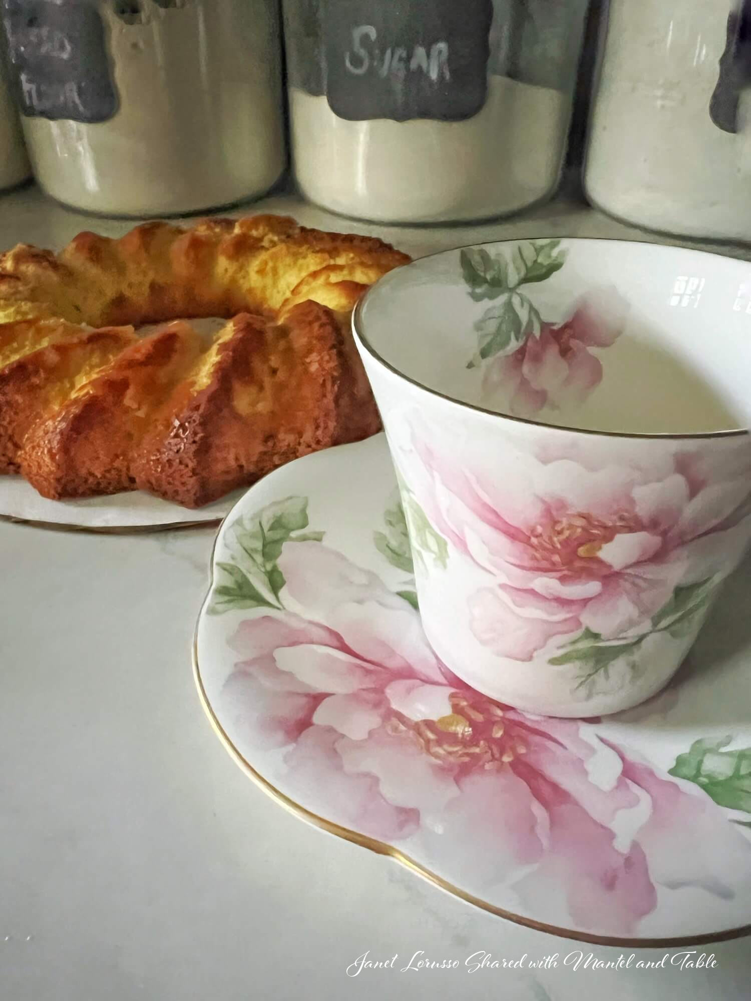 Pink flowered teacup and lemon cake on kitchen counter