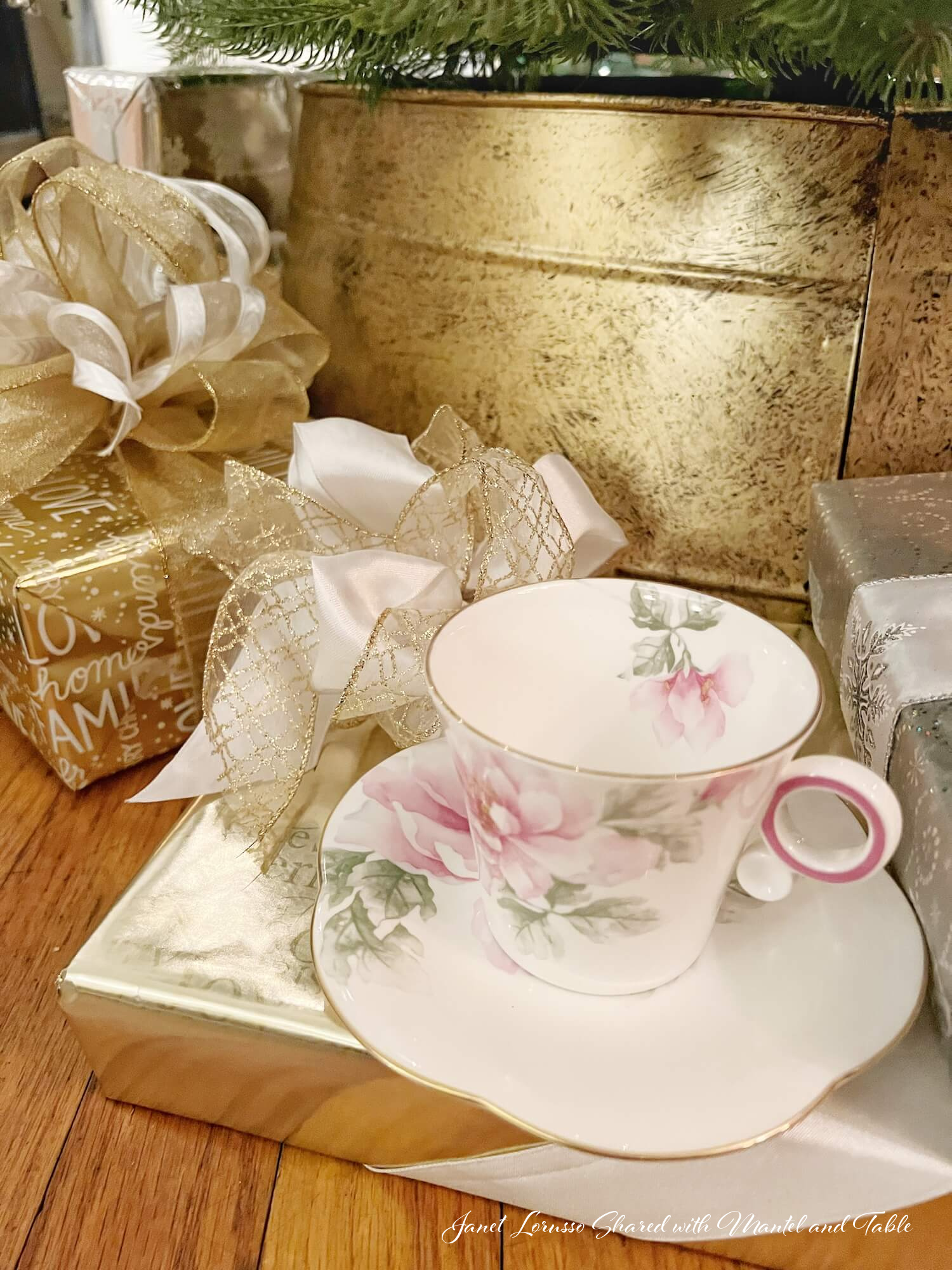 Traveling Teacup celebrates next to gold and white wrapped gifts