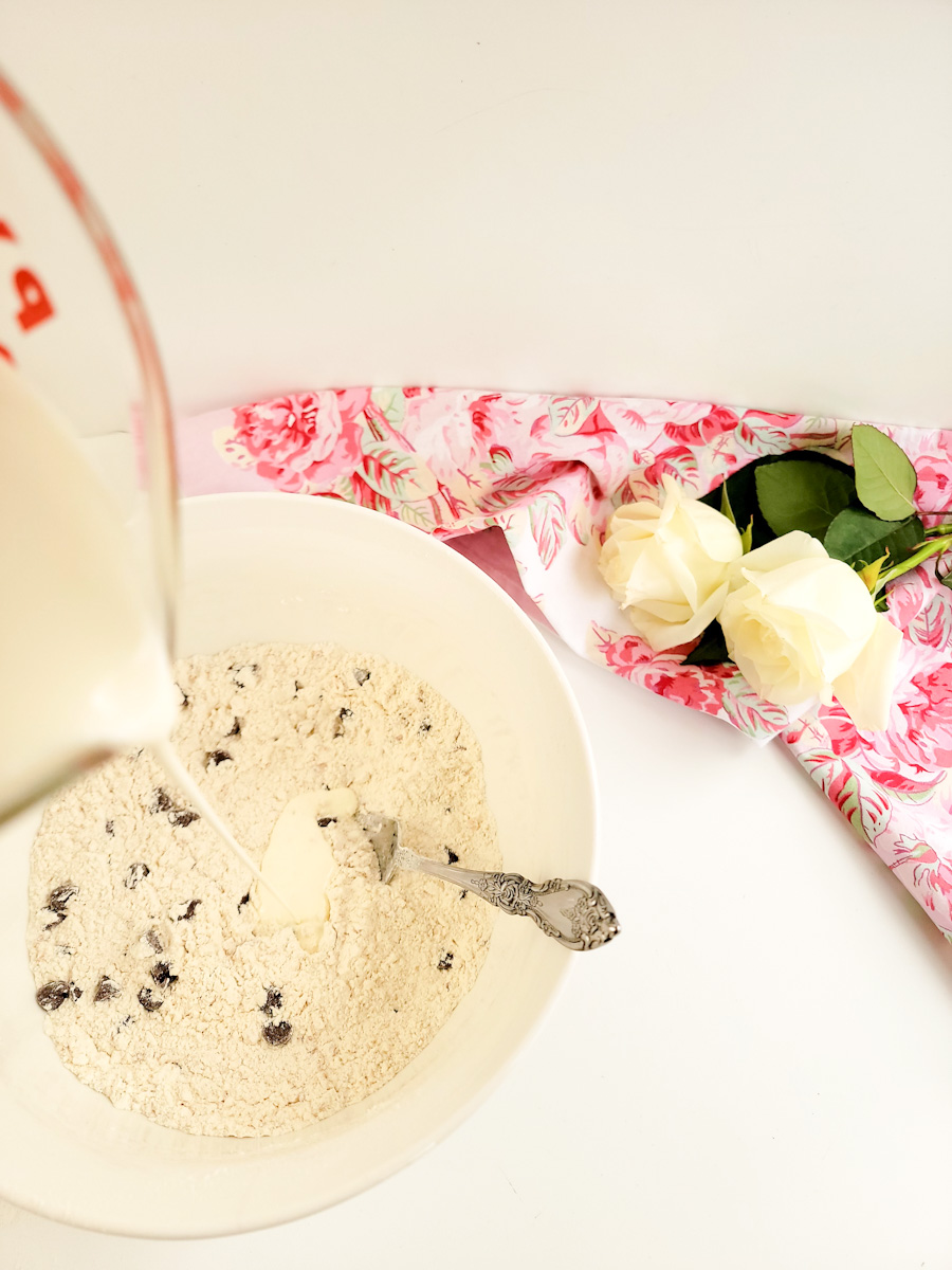 Cream being poured into a bowl of scone mix