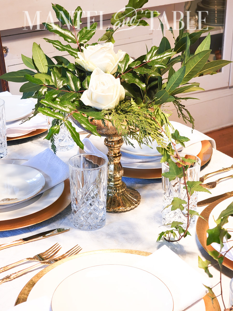 winter flower arrangement with evergreens on a set table