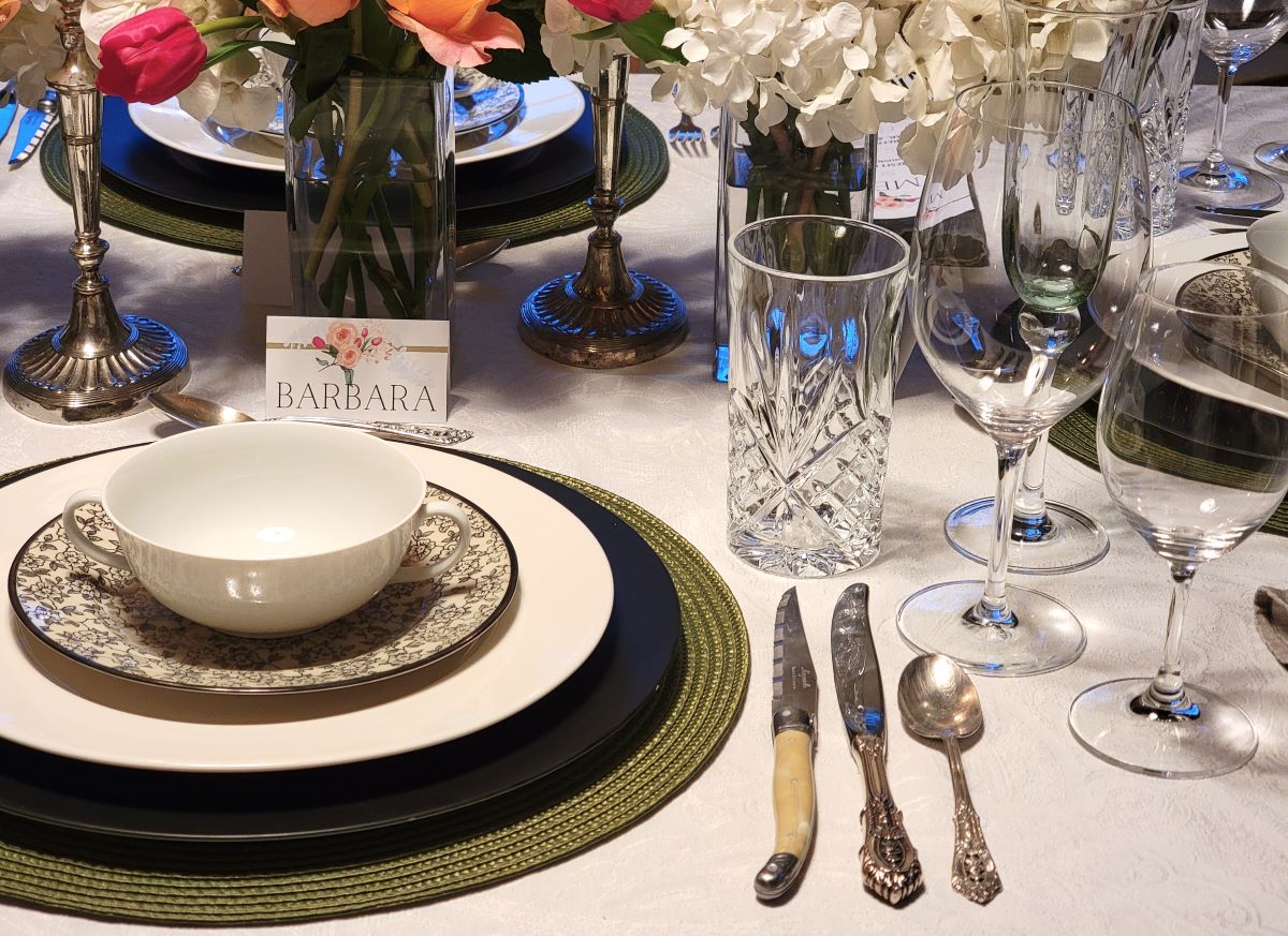 Closeup of olive green, black and white place setting