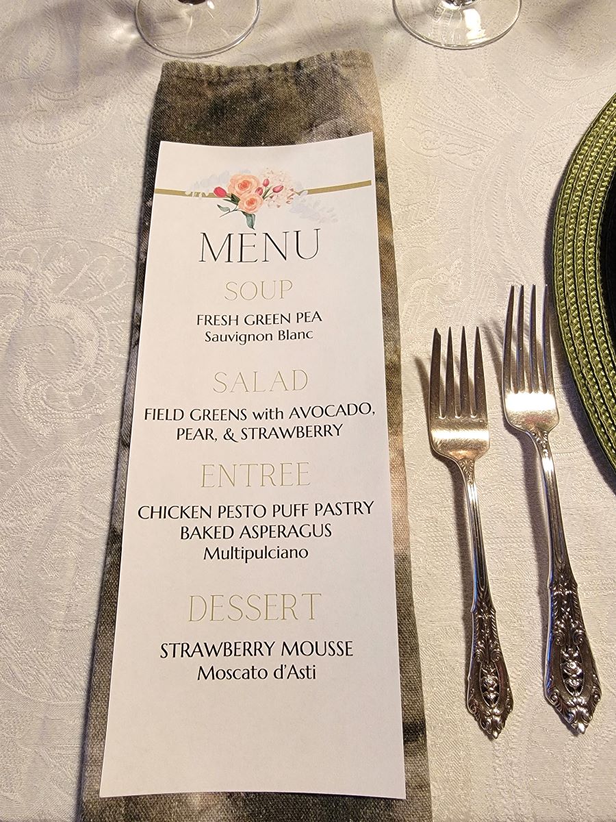 Printed menu on a napkin, listing Strawberry Mousse for dessert