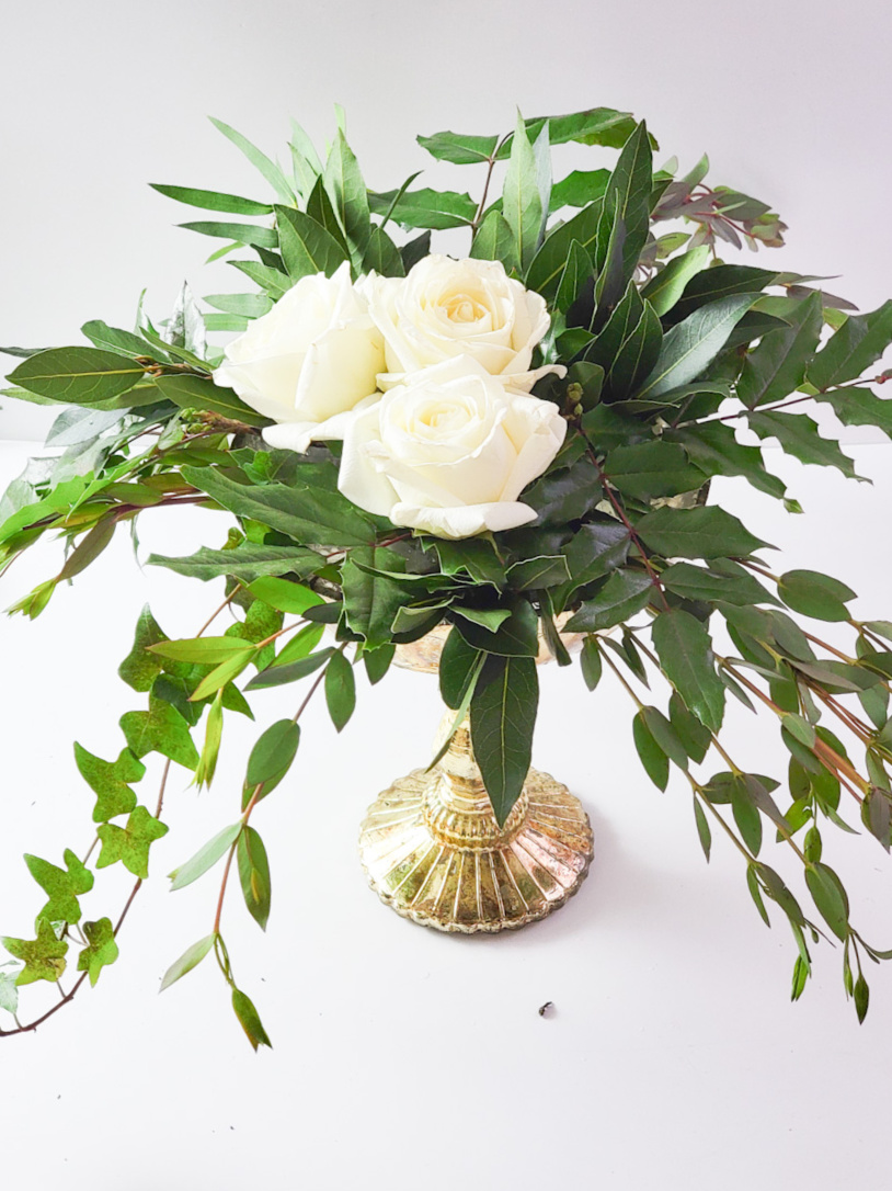 winter flower arrangement with white roses in a group of three