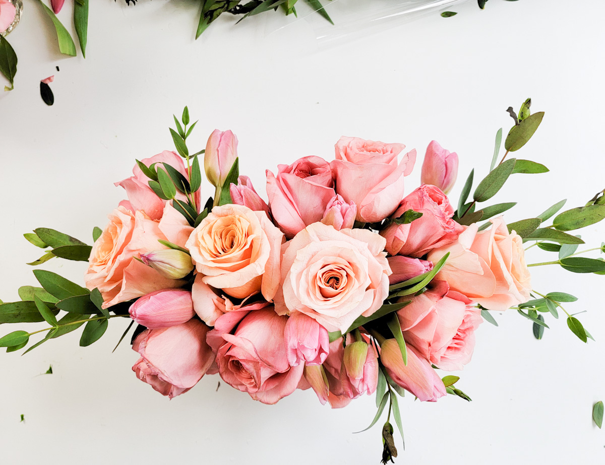 Top view of rose and tulip centerpiece with greenery