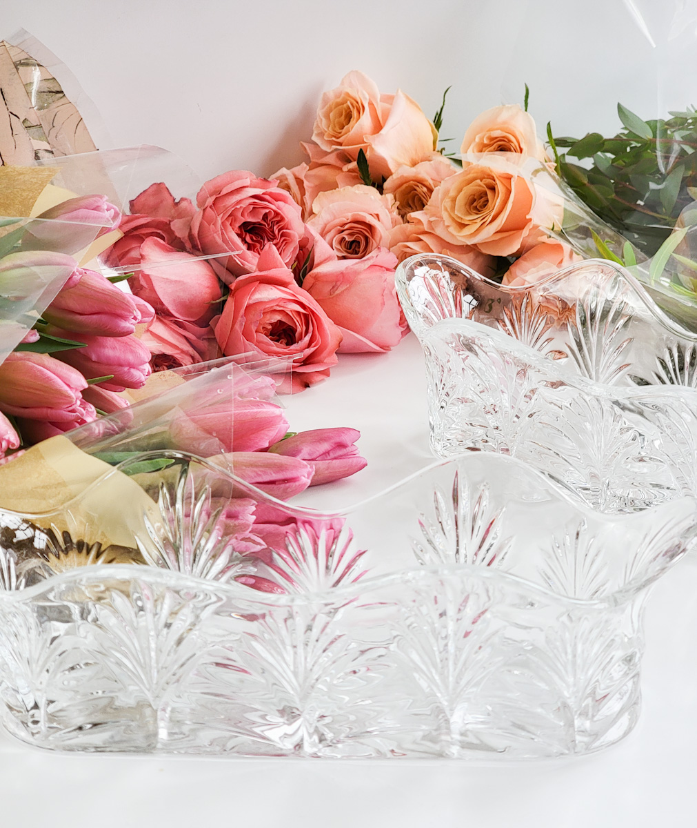 Crystal vases with packages of pink and peach roses
