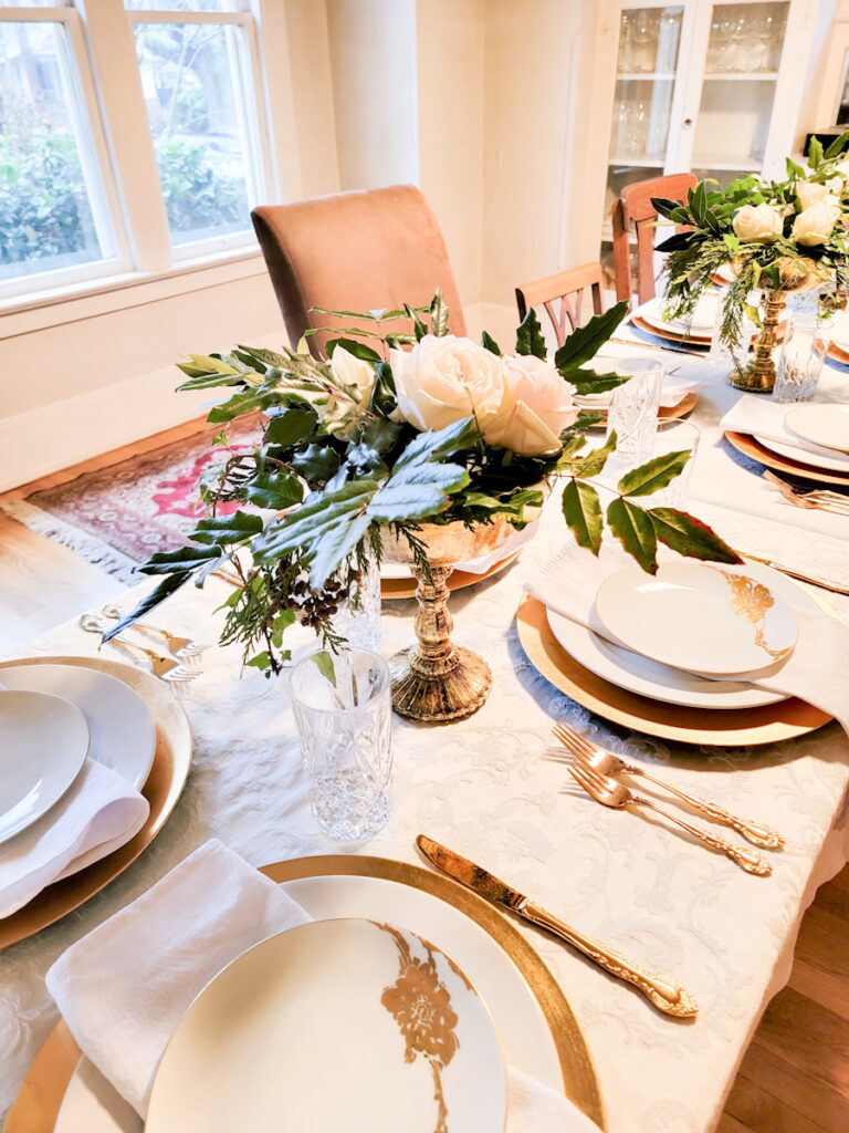 Long table set with white and gold, and winter flower arrangement