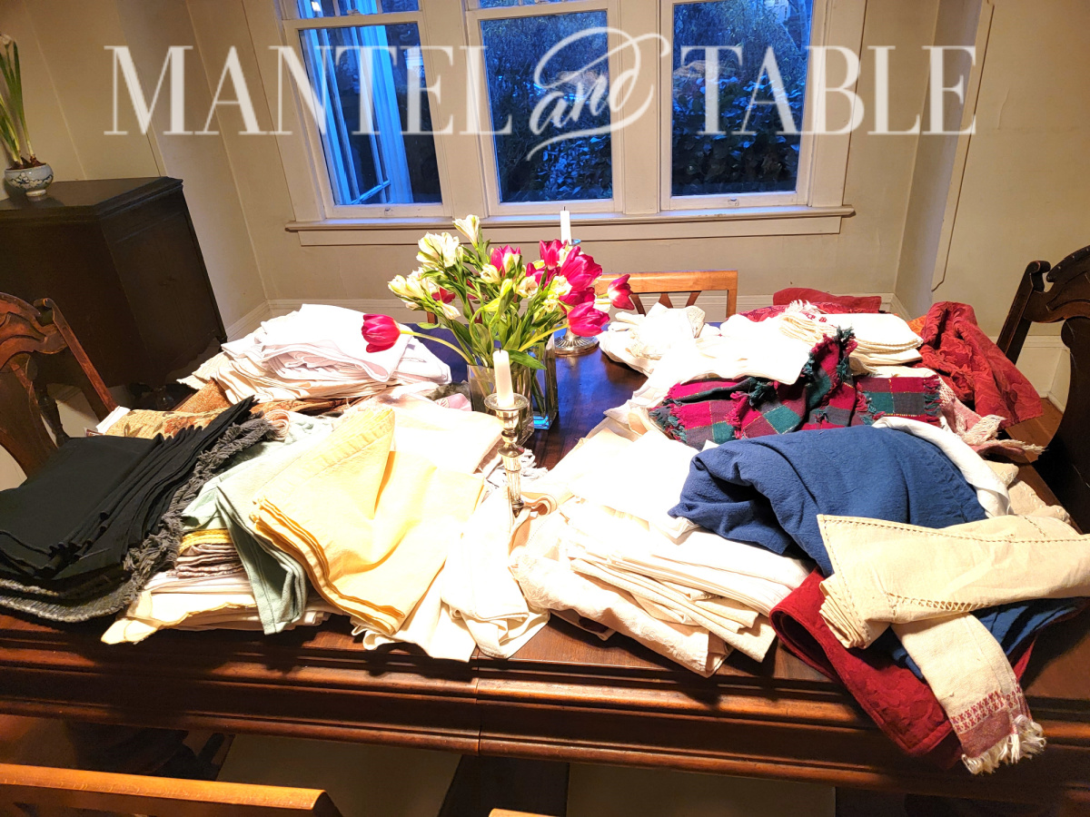 Piles of table linens on a dining room table