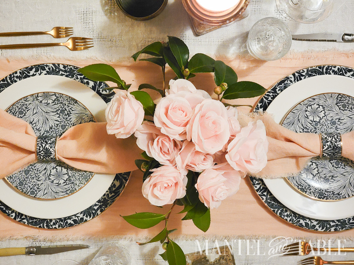 Pink rose and greenery centerpiece on table from above