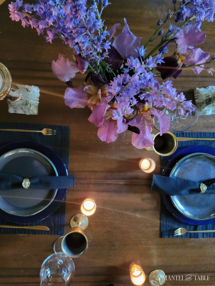 Purple iris and bluebell flower arrangement on tablescape from above