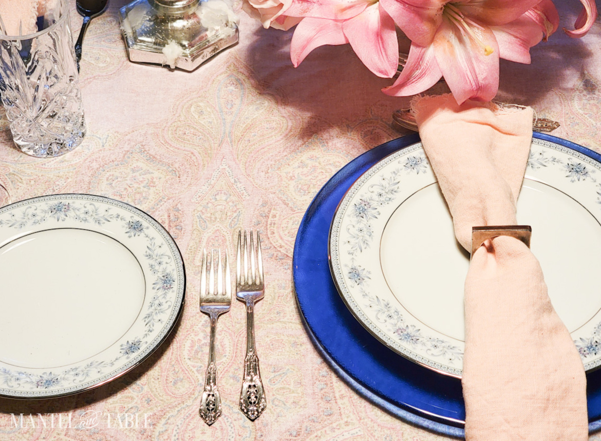 Closeup of plate stack and flatware on a set table