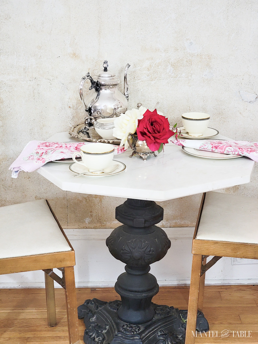table with silver tea set and red rose centerpiece side view