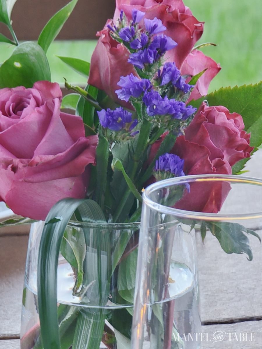 Mauve roses and purple flowers in a table setting centerpiece